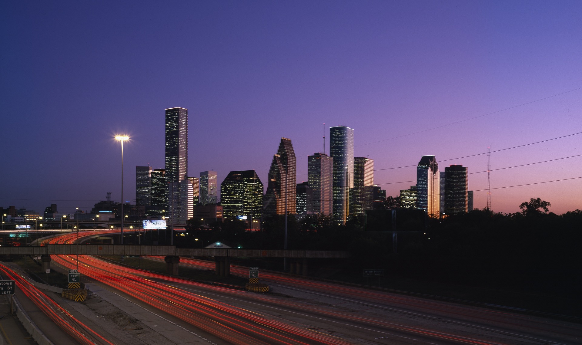 Houston skyline at dusk above freeway light trails